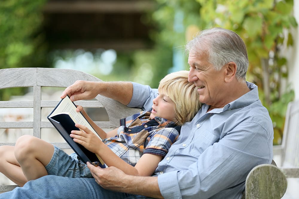 grandson reading with grandfather